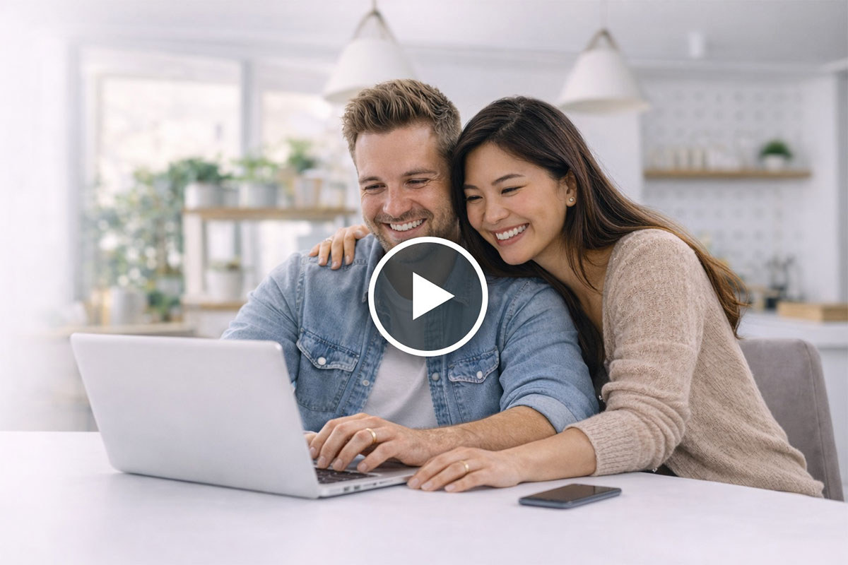 a smiling husband and wife looking at their laptop screen
